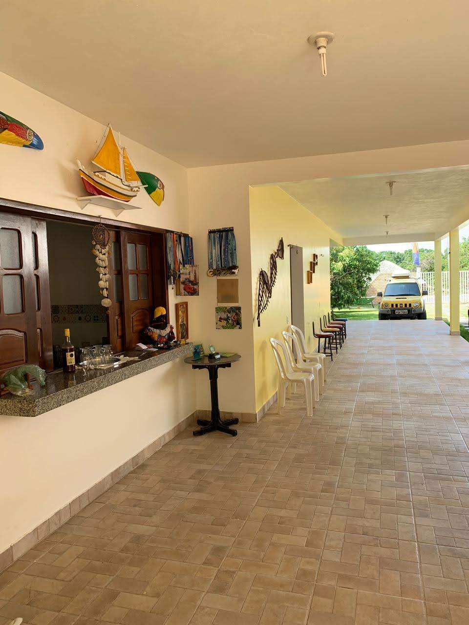 Varanda com bar, mesas e área de convivência da pousada